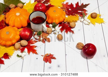 Bright Fall Horizontal Background With Orange Pumpkins And Red Apples, Nuts, Cup Of Tea, Green And Y