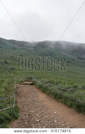 Trail On A Mountain Range Towards Tarnica In A Dense Fog In Bieszczady, Poland. Vertical Orientation