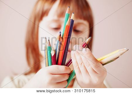 Humoroous Portrait Of Great Artist. Cute Little Child Girl With Colored Pencils. Selective Focus.