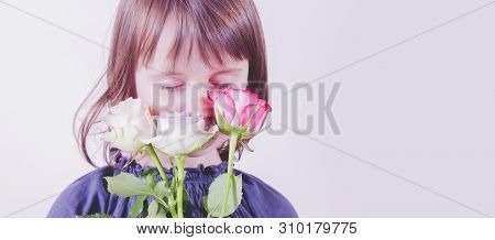 Gender Identity Development In Early Childhood Concept.cutel Little Child Girl Sniffs Roses Flowers.