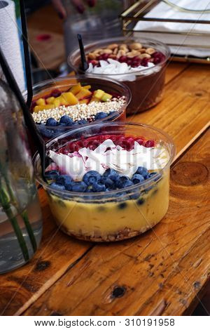 Smoothie Bowl On Street Food Festival With Fresh Raspberries And Coconut. Vegan Nicecream