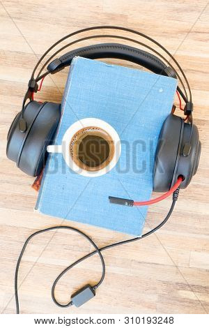 Audio Book Concept. Black Headphones With Books And Cup Of Fresh Coffee On Wooden Table. Top View