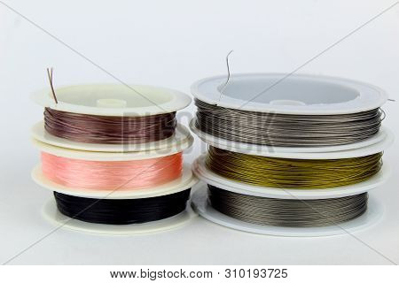 Colored Wire For Making Jewelry From Natural Stones And Natural Materials. Wire On White Plastic Coi