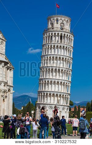 Pisa, Italy - April, 2018: Tourists Posing And Taking Pictures In Front Of The Famous Leaning Tower