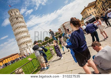 Pisa, Italy - April, 2018: Tourists Posing And Taking Pictures In Front Of The Famous Leaning Tower