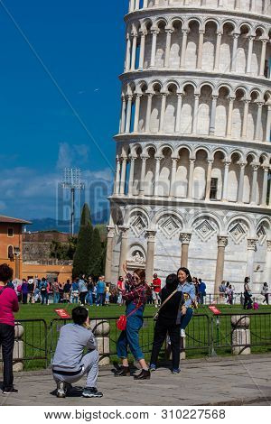 Pisa, Italy - April, 2018: Tourists Posing And Taking Pictures In Front Of The Famous Leaning Tower