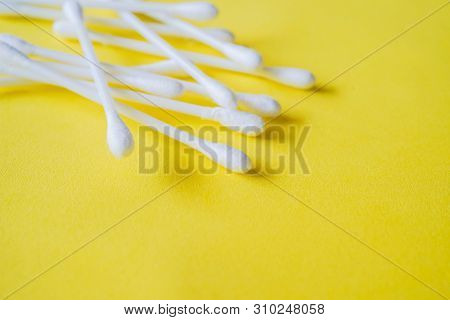 Closeup Of Cotton Buds, In Soft Focus, Isolated On Yellow Background