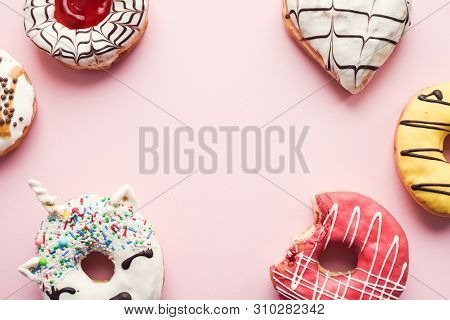 Pink Frosted Donut With Bite Missing With Assortment Donuts On Pink Background With Place For Text. 