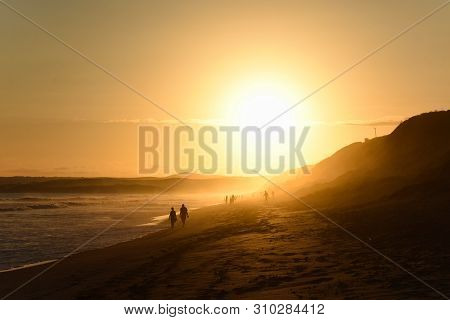 Elderly Couple Walking On Afternoon Sunset Beach, Mossel Bay, South Africa