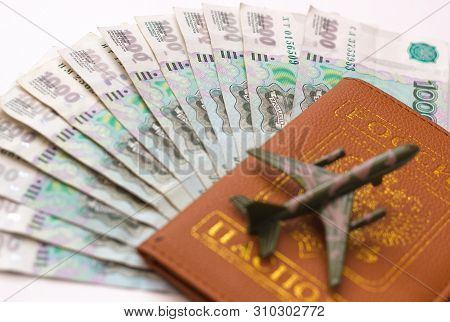Russian Money And Passport On White Background, Close-up, Passport And Money Fan In Hand. Travel Age