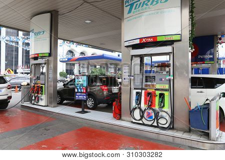 Manila, Philippines - December 7, 2017: People Fill Cars At Petron Gas Station In Manila, Philippine