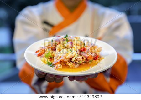 Traditional Thai Spicy Noodle Vermicelli With Seafood Shrimp Squid And Thai Herb On Cook Hand.