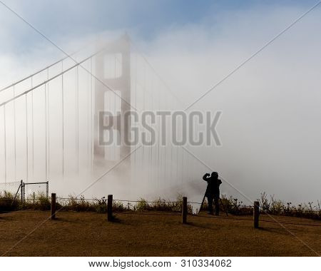 The Silhouette Of Unidentified Photographer Shooting The Golden Gate Bridge With A Camera And A Cell