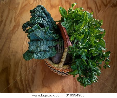 Closeup On Organic, Natural-looking Vegetables And Herbs  In The Summer, In Woven Basket, On Wooden 