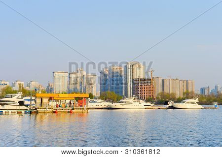 Yachts In Marina With A Gas Station. Modern City Architecture In The Background. Kiev, Ukraine