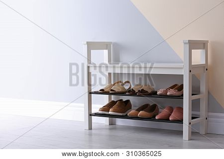 Shoe Rack With Different Footwear Near Color Wall, Space For Text. Stylish Hallway Interior