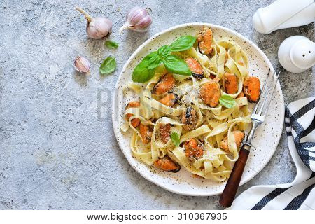 Tagliatella Pasta With Mussels And Cream Sauce On The Kitchen Table. View From Above.