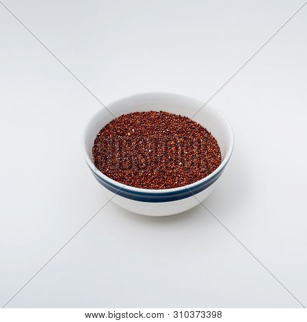 Closeup On White  Ceramic Bowl With Raw Red  Quinoa On White Background, Filled By The Two-thirds  D