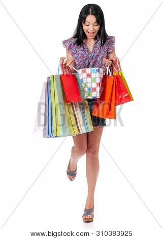 Full length portrait of young shopaholic shopping woman holding many shopping bags, isolated over white background
