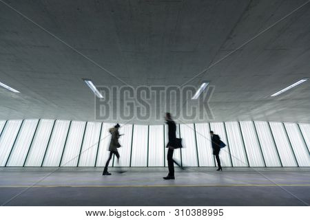 Motion blurred people - figures in an underpassage getting to their workplace in the morning. Busy city business life.