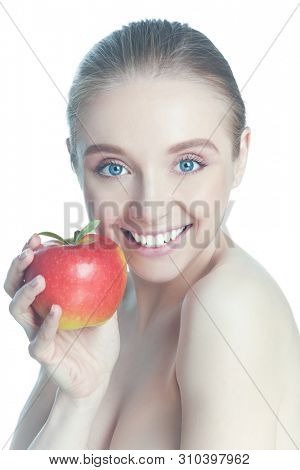 Portrait of happy smiling young beautiful woman eating red apple, over white background