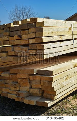 Stacked Lumber On Blue Sky.folded Wood.closeup Wooden Boards.the Surface Of The End Of The Board.lot
