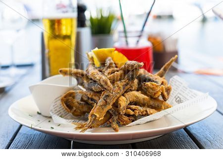 Crispy Fried Black Sea Anchovies (hamsi) With Lemon And Garlic Sauce At The Romanian Seaside