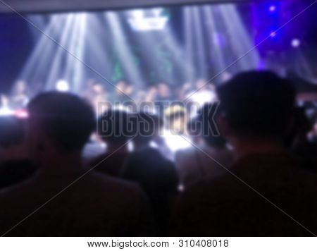 Blurred Crowd Of Enjoyment Peolple In Night Disco Club Background.