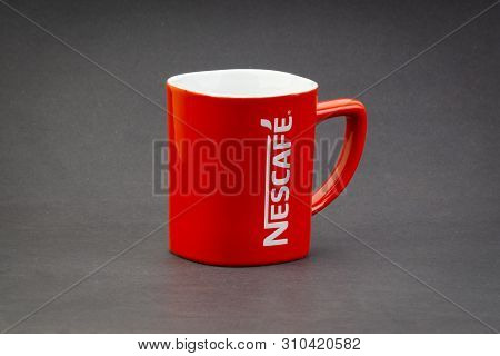 Kuala Lumpur, Malaysia - July 03, 2019; Promotional Red Nescafe Mug On Dark Background. Selective Fo