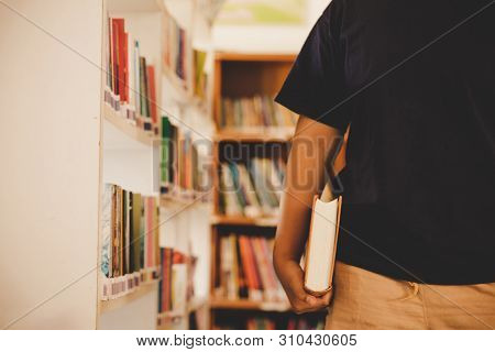 In The Library - Young Girl Student With Books Working In A High School Library.