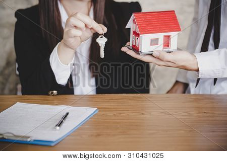 Real Estate Agent With House Model And Keys