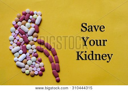 Medicine Pills Tablets Capsules In Shape Of Human Kidney In Yellow Background With Space For Text
