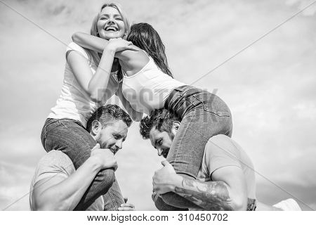 Couples In Love Having Fun. Men Carry Girlfriends On Shoulders. Summer Vacation And Fun. Couples On 
