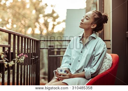 Peaceful Good-looking Woman In Oversize Male Shirt Carrying Big Cup