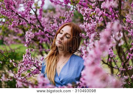 Beautiful Dreaming Redhead Woman In Spring Time Blossom Cherrytrees Garden.