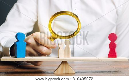 Wooden Figures Of People On Scales. The Court Decision On Custody Of The Children By One Of The Pare