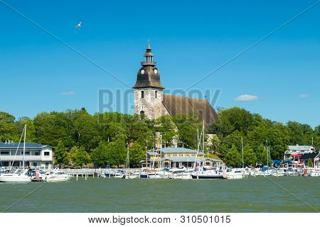 Naantali, Finland - 28 June, 2019: View From The Sea Of Naantali Harbor And Medieval Stone Church At