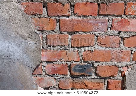 Old And Flaky Wall Of A City Building Of Red Bricks (fragment)