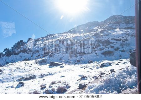 Sun On Top Of Snow Cover Himalaya Range. Frozen Rocky Peak Filled With Deep Snow Illuminate Rising S