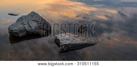 Calm, Serenity, Meditation Concept. Sunset On The Lake, Stones In The Water In The Foreground, Quiet