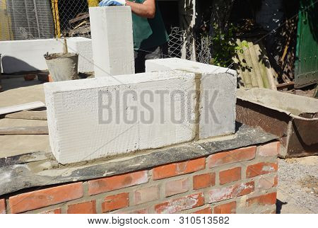 Bricklayer Builder Laying Autoclaved Aerated Concrete Blocks, Aac On House Foundation Wall.