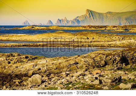Seascape On Andoya Island. Scenic Rocky Coastline With Mountain Peaks In Distance, View From Bukkekj
