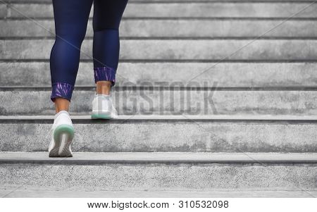 Female Runner Athlete Doing A Stairs Climbing. Running Woman Doing Run Up Steps On Staircase In Urba