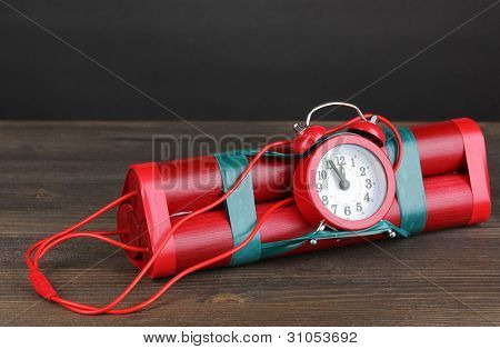Timebomb изготовлены из динамита на деревянный стол на сером фоне