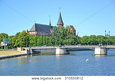 Kaliningrad, Russia - June 18, 2019: Derevyanny Bridge Against The Background Of The Konigsberg Cath