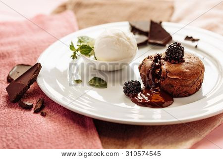 Chocolate Fondan With Syrup And Ice-cream On A Plate Decorated With Mint Leaves.