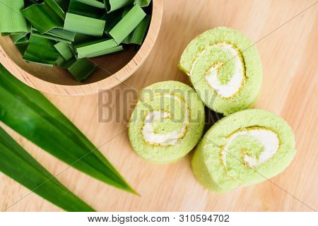 Pandan Roll Cake And Fresh Pandan Leaf On Wooden, Top View
