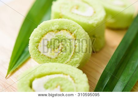 Pandan Roll Cake And Fresh Pandan Leaf On Wooden