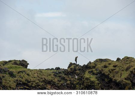 Tourist Posing On The Londrangar Basalt Cliff, Iceland