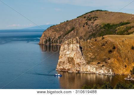 Small Ship On The Background Of Large Rocks.. Boat Sails On Lake Baikal.